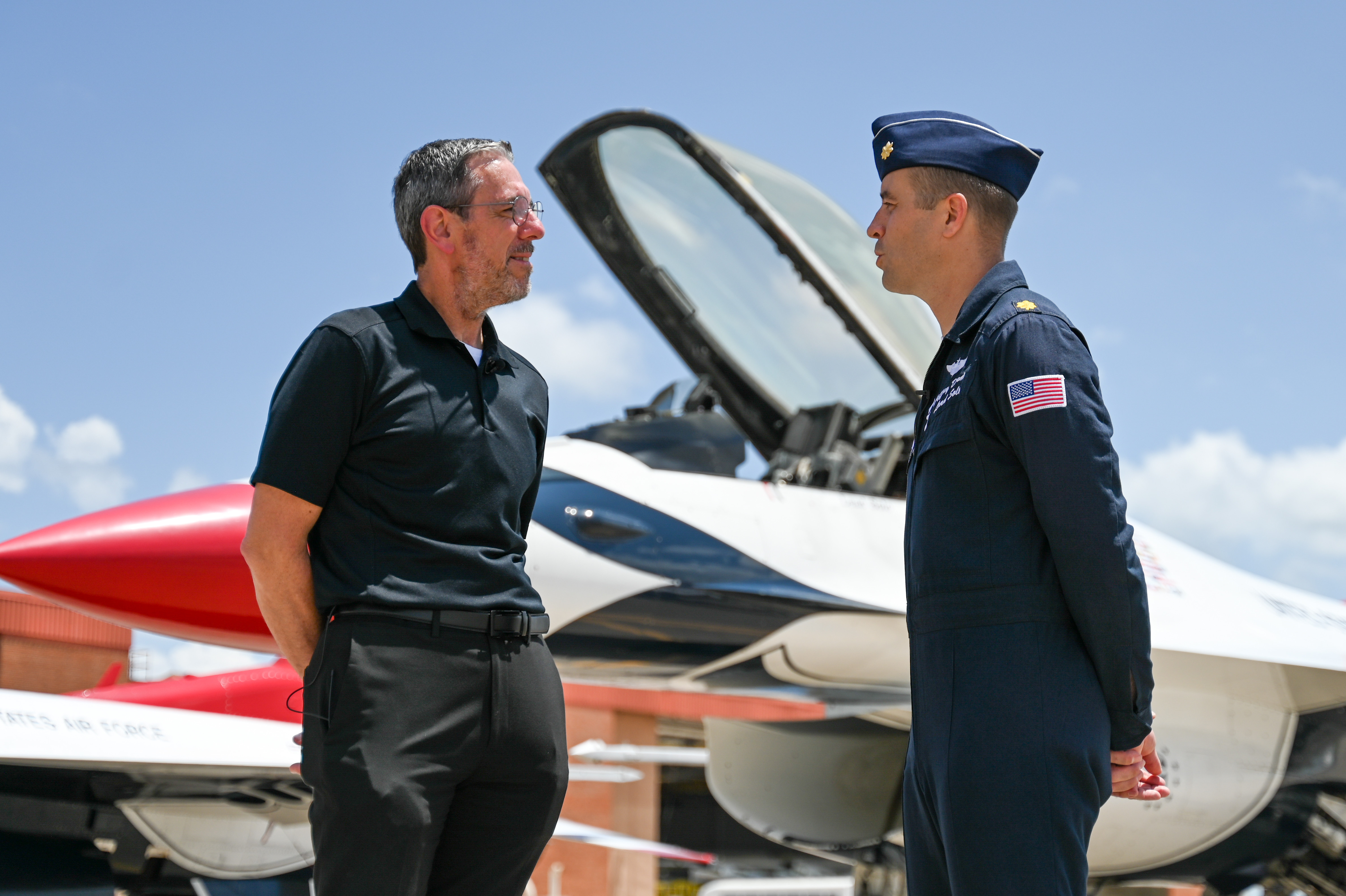 Two men talking in front of jet